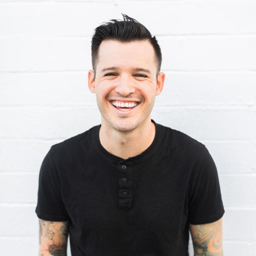 Homme souriant contre un mur blanc