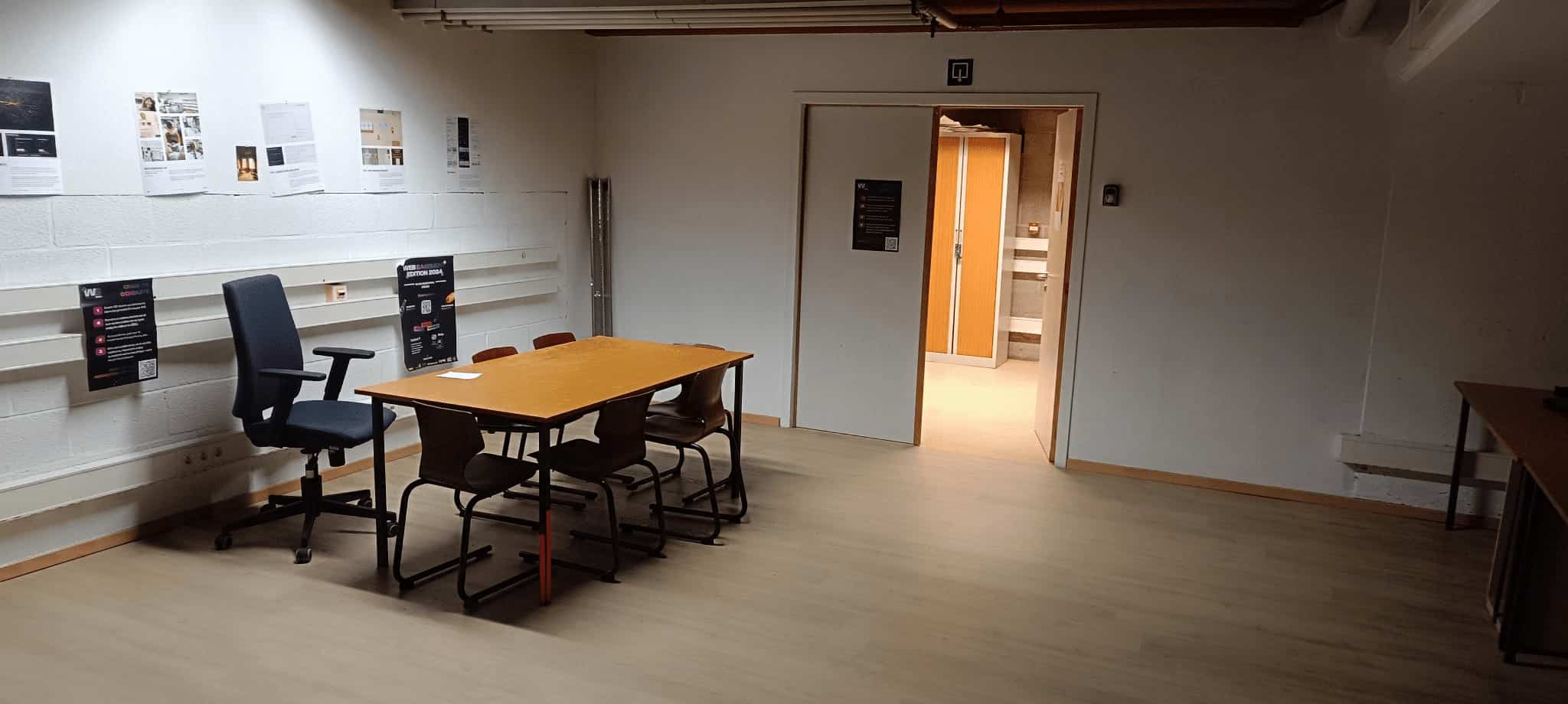 Coin avec une table et des chaises et une porte qui mène sur une autre salle